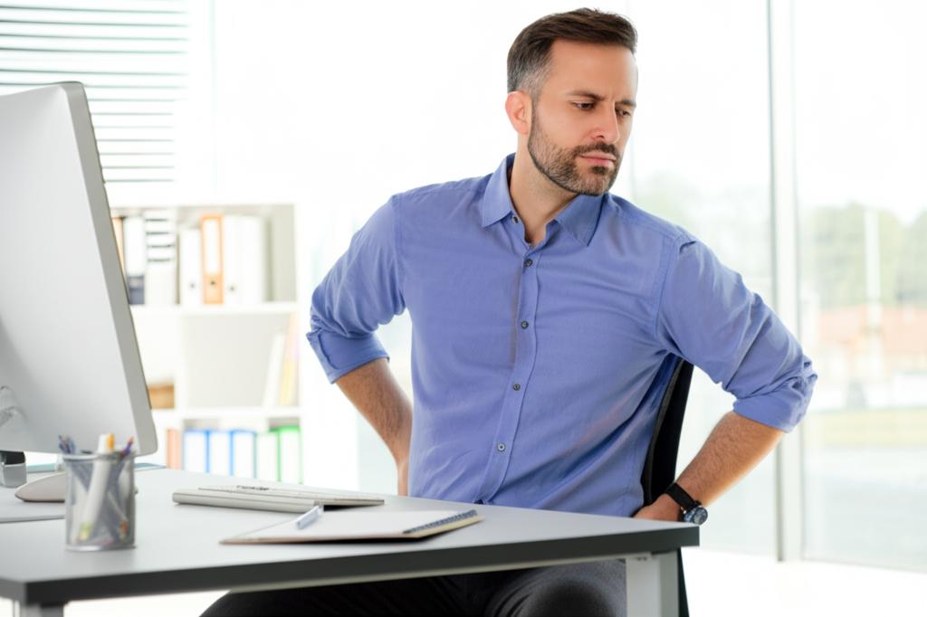 Worried office worker sitting at desk with back pain and fatigue, looking stressed.
